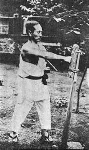 Gichin Funakoshi training with a makiwara